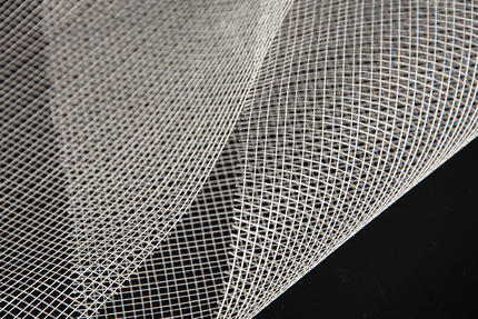 What is fiberglass laid scrim, and how is it manufactured from fiberglass materials
